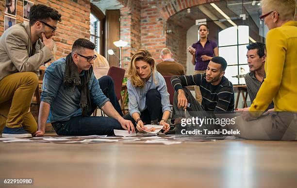 werbung agentur team sie modell für kampagne - auf dem boden sitzen stock-fotos und bilder