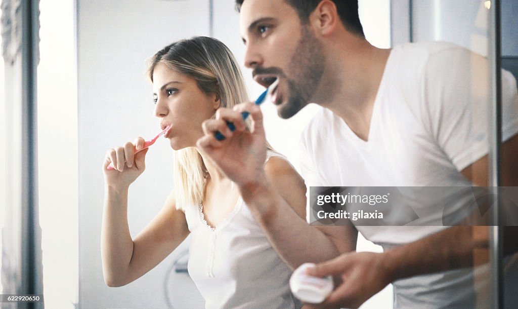 Couple brushing teeth in the morning.