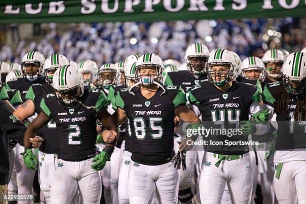 The Marshall Thundering Herd take the field with locked arms after the 1970 team haas honored prior to the NCAA Football game between the Middle...