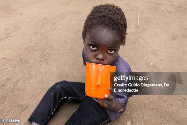 thirsty boy with cup of water (malawi, 2016) - bony stock pictures, royalty-free photos & images