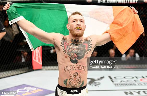 Conor McGregor of Ireland celebrates his KO victory over Eddie Alvarez of the United States in their lightweight championship bout during the UFC 205...