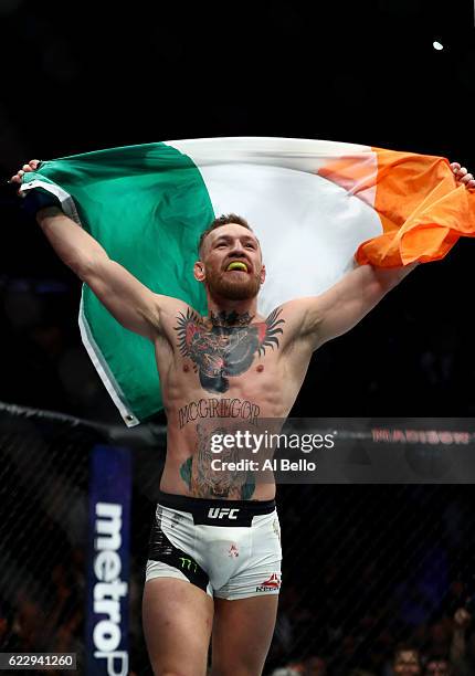 Conor McGregor of Ireland celebrates his KO victory over Eddie Alvarez of the United States in their lightweight championship bout during the UFC 205...