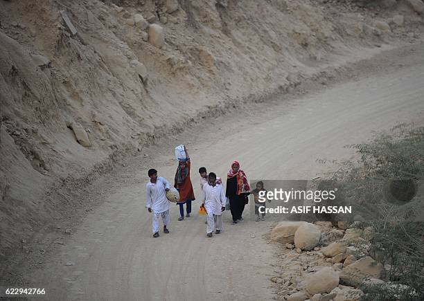 Pakistani devotees walk back home from the shrine of Sufi saint Shah Noorani, some 750 kilometres south of Quetta on November 13 following the...