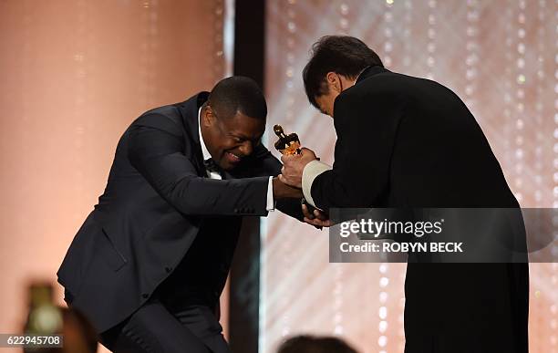 Honoree Jackie Chan is presented with an Honorary Oscar Award by actor Chris Tucker during the 8th Annual Governors Awards hosted by the Academy of...