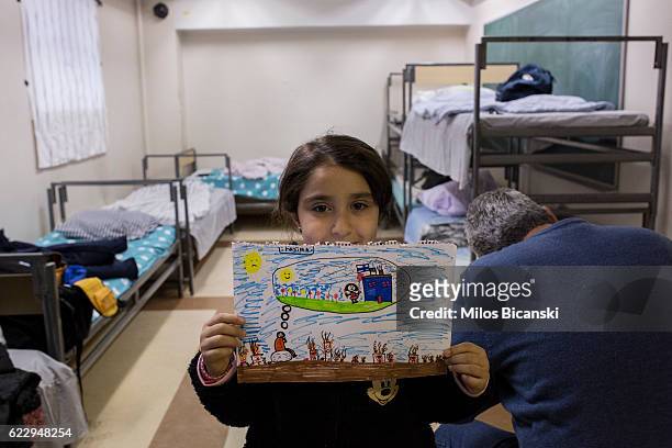 Syrian refugee Fatima Asaaid Alkhateb shows her drawing illustrating a child's dream in Syria, in her family room in Joutseno reception center on...