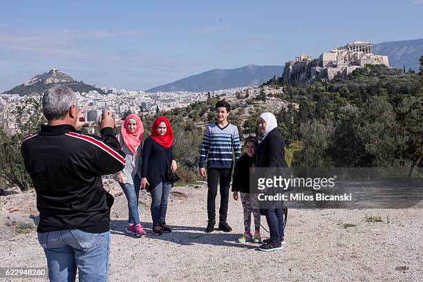 Syrian refugee Hassan Asaaid Alkhateb photographs his family in front of Acropolis Hill, the day before travelling to Finland, on October 30, 2016 in...