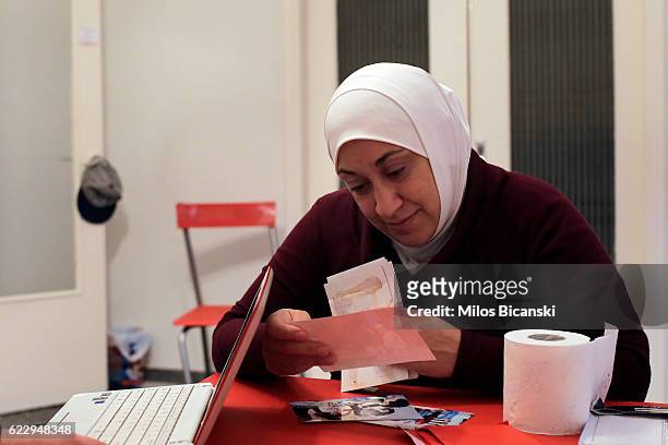 Syrian refugee, Lama Asaaid Alkhateb looks at photos of her family's life before the war in Syria, in her temporary Athens home on October 29, 2016...