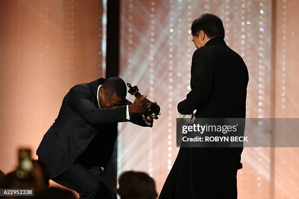 Actor Chris Tucker presents an honorary Oscar award to actor Jackie Chan during the 8th Annual Governors Awards hosted by the Academy of Motion...