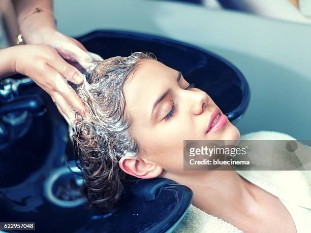 lavage des cheveux dans le salon de coiffure - femme shampoing photos et images de collection