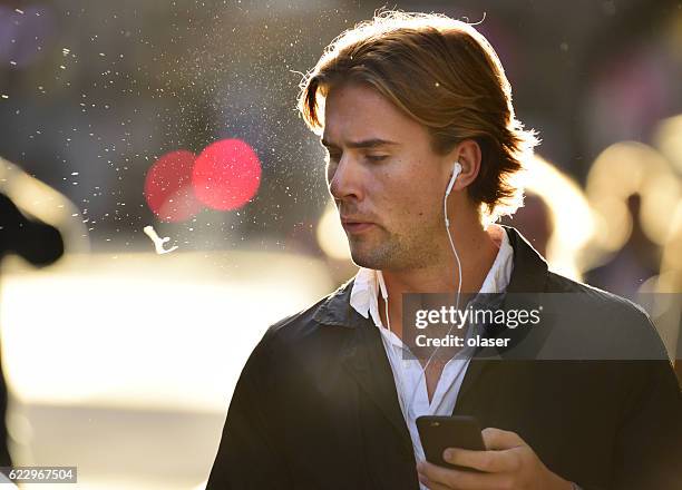 man spitting and using mobile smart phone - spitting stock pictures, royalty-free photos & images