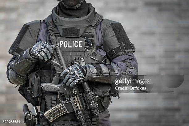 officier de police swat contre le mur de briques - anti-terrorisme photos et images de collection