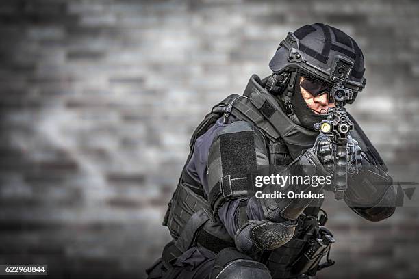 swat police officer against brick wall - special forces stock pictures, royalty-free photos & images
