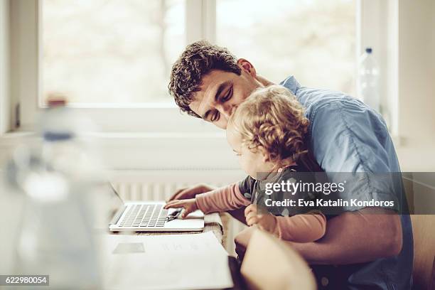 fahter is showing his daughter things on a laptop - family budget stock pictures, royalty-free photos & images