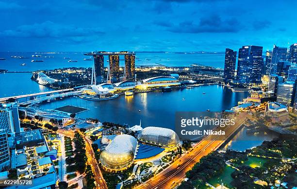 aerial view singapore, marina bay at dusk - singapore stock pictures, royalty-free photos & images