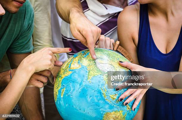 teenagers searching place on a globe - world children day stock pictures, royalty-free photos & images