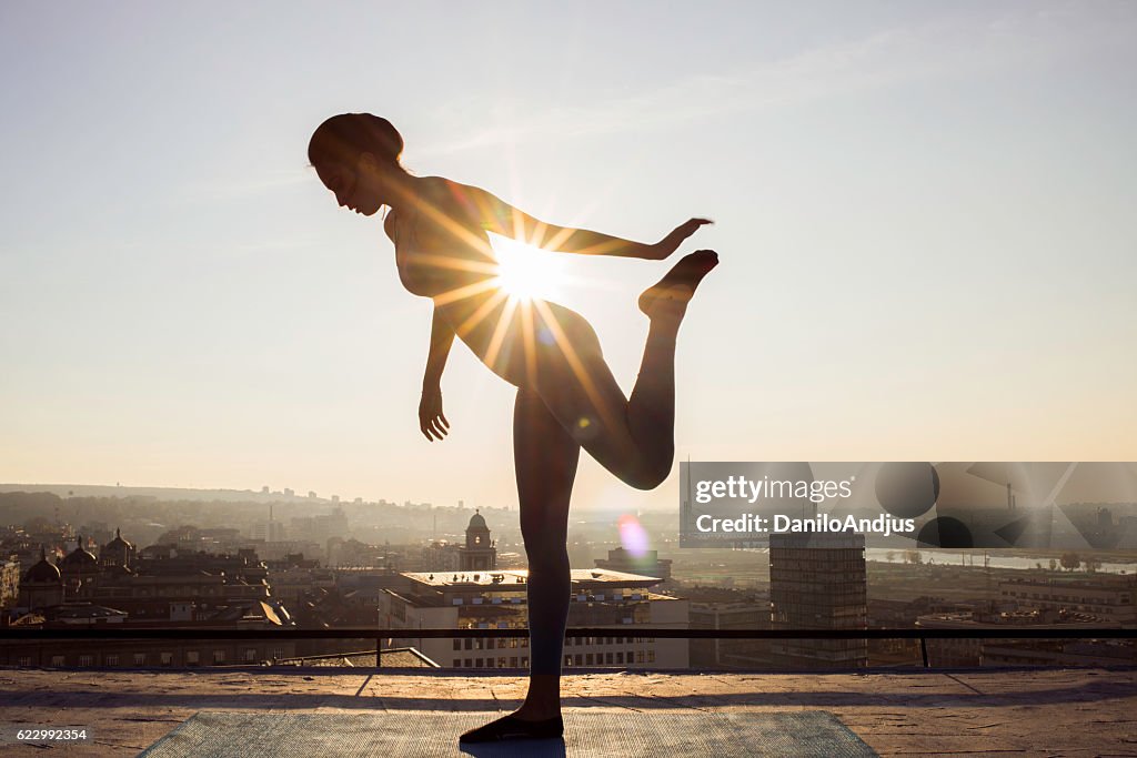 Woman stretching on the rooftop before working out