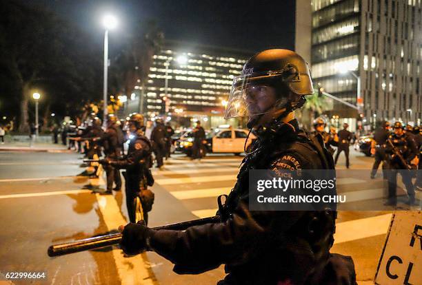 Police in riot gear stand guard outside City Hall during a protest against US President-elect Donald Trump in Los Angeles, California, on November...