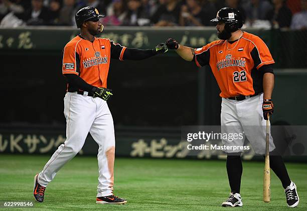 Infielder Yurendell de Caster of the Netherlands high fives with his team mate Catcher Shawn Zarraga after hitting a sacrifice fly in the fourth...