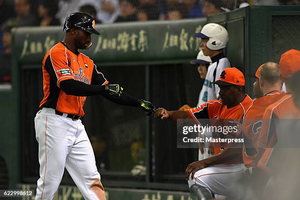 Infielder Yurendell de Caster of the Netherlands celebrates with Head coach Hensley Meulens after hitting a sacrifice fly in the fourth inning during...