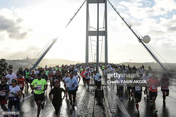 Participants run on the July 15 Martyrs' Bridge, known as the Bosphorus Bridge, during the 38th annual Istanbul Marathon on November 13, 2016. / AFP...