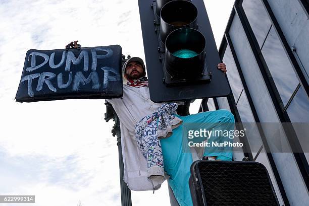 Protester who climbed a traffic light during an anti-Trump protest in Los Angeles, California November 12, 2016. According to the LAPD an estimated...