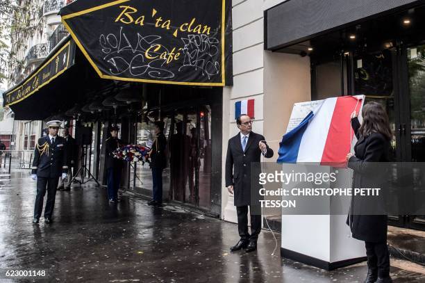 French President Francois Hollande and Paris' Mayor Anne Hidalgo unveil a commemorative plaque at the Bataclan concert hall in Paris on November 13...