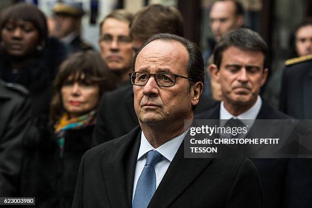 French President Francois Hollande stands after unveiling a commemorative plaque in front of the Comptoir Voltaire cafe on Boulevard Voltaire in...