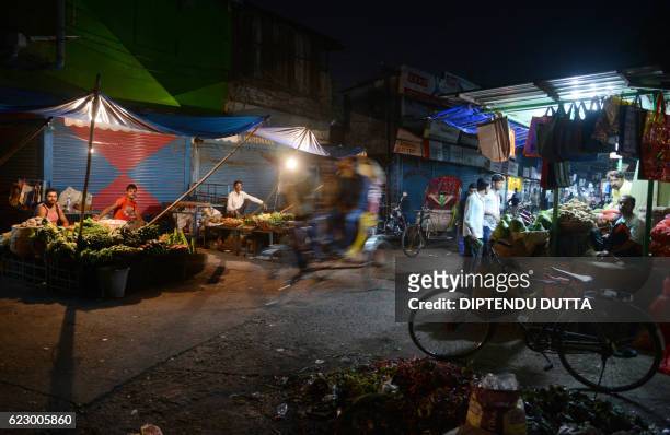 Indian vegetable vendors wait for customers during a drop in custom following the decision to withdraw the current 500 and 1000 INR notes in Siliguri...