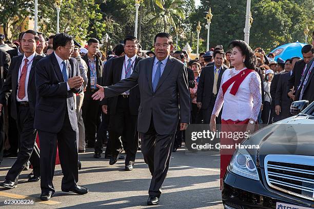 Cambodian Prime Minister Samdech Hun Sen and First Lady Bun Rany greet authorities as they arrive at the Royal Pavilion on the Tonle Sap river during...