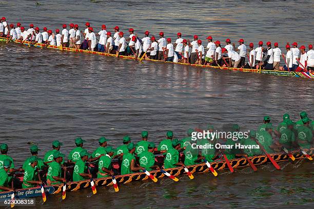 Boat crew members train on the waters of the Tonle Sap River on the morning of the first day of the Water Festival on November 13, 2016 in Phnom...