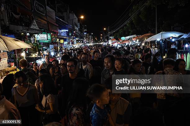 Crowd of people walk through a weekend market in the popular tourist city of Chiang Mai in the north of Thailand on November 13, 2016. Restrictions...
