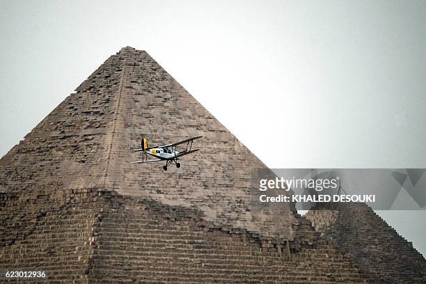 Belgian pilots Alexandra Maingard and her husband Cedric Collette fly their vintage Stampe OO-GWB biplane by one of the Pyramids of Giza, on the...