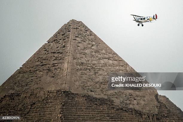Belgian pilots Alexandra Maingard and her husband Cedric Collette fly their vintage Stampe OO-GWB biplane by one of the Pyramids of Giza, on the...