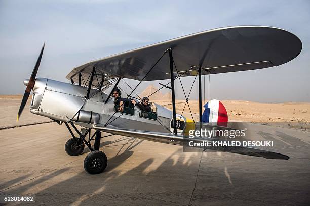 Egyptian pilot Yasser Menaissy and Belgian pilot Cedric Collette sit in a vintage Stampe OO-GWB biplane in an airfield near the Pyramids of Giza, on...