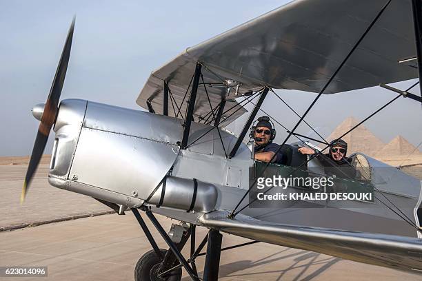 Egyptian pilot Yasser Menaissy and Belgian pilot Cedric Collette pose for a photo in a vintage Stampe OO-GWB biplane in an airfield near the Pyramids...