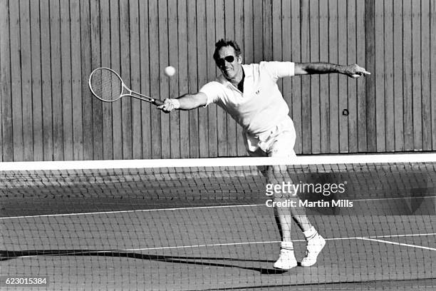 American actor Charlton Heston plays tennis circa 1960's.