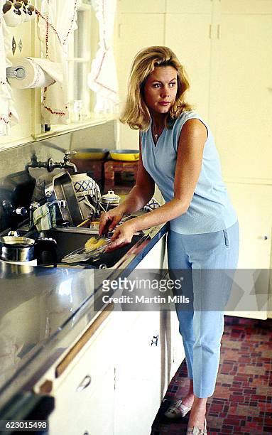 Actress Elizabeth Montgomery poses for a portrait while washing dishes at her home circa 1966 in Los Angeles, California.