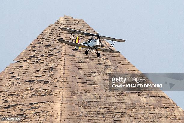Egyptian pilot Yasser Menaissy and Belgian pilot Cedric Collette fly a vintage Stampe OO-GWB biplane by one of the Great Pyramids of Giza, on the...