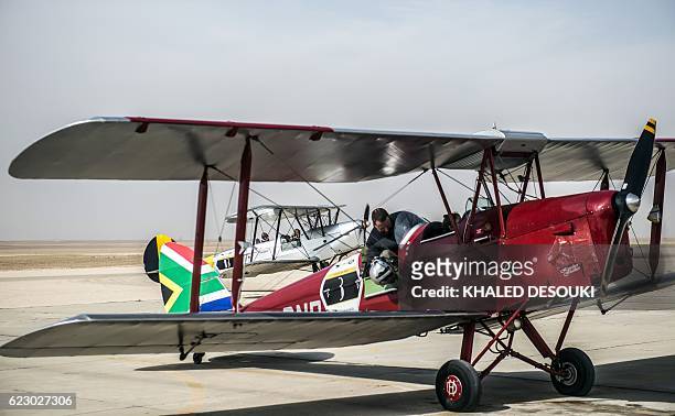 Picture taken on November 13, 2016 shows a pilot sitting in the South Africa team's DH82A Tiger Moth vintage biplane at an airfield in Cairo's 6th of...