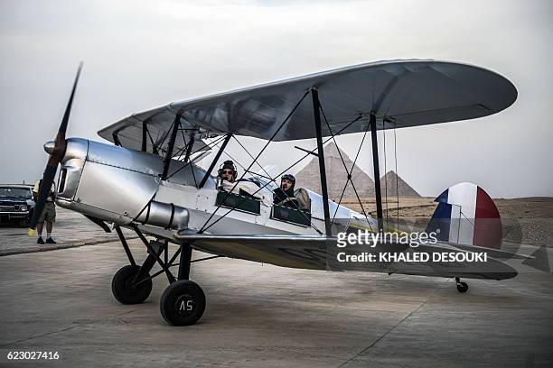 Belgian pilots Alexandra Maingard and her husband Cedric Collette prepare their biplane for takeoff at an airfield near the Pyramids of Giza, on the...