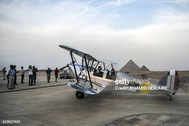 Belgian pilots Alexandra Maingard and her husband Cedric Collette prepare their biplane for takeoff it an airfield near the Pyramids of Giza, on the...