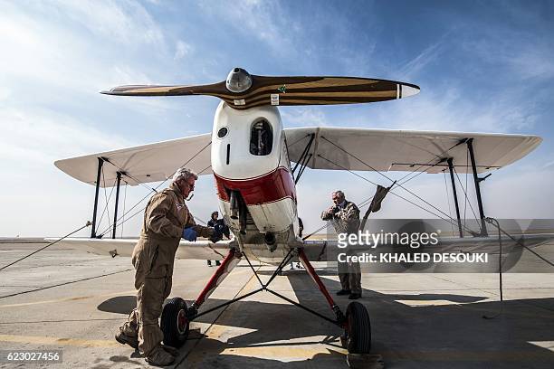 German pilot Ingo Presser checks his Bü 131 Bücker Jungmann biplane after landing at an airfield in Cairo's 6th of October City, west of the Egyptian...