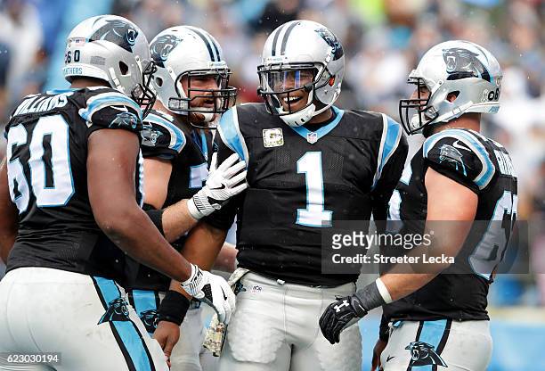 Cam Newton and teammates Daryl Williams, Mike Remmers, and Gino Gradkowski of the Carolina Panthers celebrate a 1st quarter touchdown against the...
