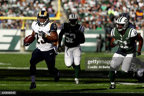 Benny Cunningham of the Los Angeles Rams runs the ball against David Harris and Julian Stanford in the first quarter at MetLife Stadium on November...