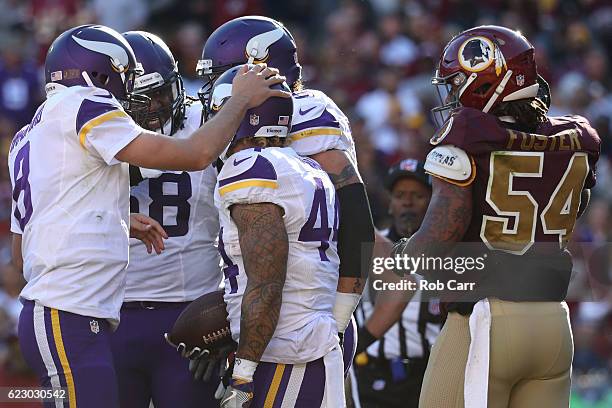 Running back Matt Asiata of the Minnesota Vikings celebrates with teammate quarterback Sam Bradford after scoring a second quarter touchdown while...