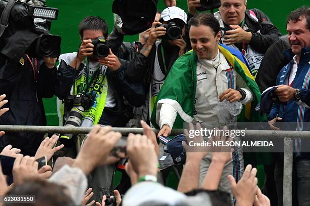 Williams Martini Racing's Brazilian driver Felipe Massa greets fans after his final appearance at Interlagos circuit before retirement, at the end of...