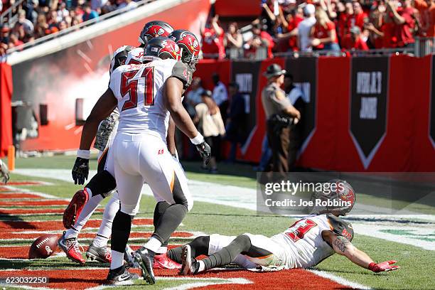 Chris Conte of the Tampa Bay Buccaneers celebrates with teammates in the end zone after returning an interception 20 yards for a touchdown against...