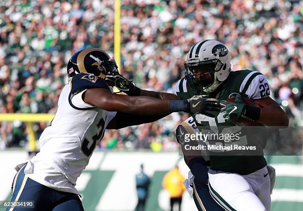 Matt Forte of the New York Jets breaks a tackle against Maurice Alexander and E.J. Gaines of the Los Angeles Rams in the second quarter at MetLife...