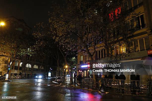 People gather at a makeshift memorial at Le Belle Equipe restaurant in Paris on November 13, 2016 to commemorate the one year anniversary of the...