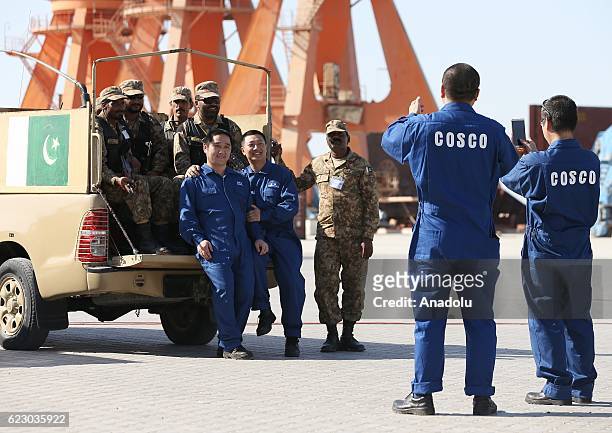 Pakistani army members and Chinese staff pose for a photo together during the opening of a trade project in Gwadar port, west of Karachi on November...